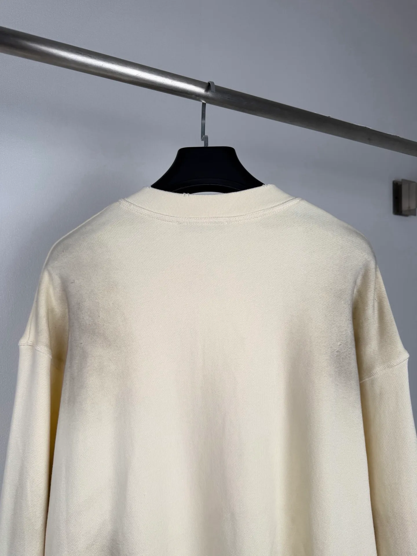 Acne Studios logo-printed distressed sweatshirt, custom-made fleece-soled sweatshirt, thick and soft, warm to the touch, Cream White ready-to-wear, warm matte texture spread across the fabric, slowly spreading the unique Scandinavian cool and luxurious charm, Henry collar half-button placket outlines the soft collar line, elegantly modifies the neck contour, mottled red brand letter print engraved on the body, Retro worn texture contains narrative heritage Ribbing tightly locks the cuffs and hem, firmly shaping the body, loose and relaxed shoulder silhouette, eliminating redundant decorations. The collision between the soft background color and retro printing interprets the minimalist, relaxed and elegant style of Acne Studios. Process 1: Use an imported fully automatic flat screen printing machine to print the special printing slurry containing microcapsule foam particles on the surface of the fabric. After being heated in a high-temperature drying tunnel, the microcapsules in the slurry expand and swell when cooled and set. Process 2: Gradient distressed spray process. By spraying dyes of different colors on the surface of the fabric, the clothes can show rich color changes under different lights and increase the visual layering. Process 3: Positioned manual fraying. Local friction and wear on the fabric through manual operations. The surface of the fabric will form a natural damage effect. It is time-consuming and labor-intensive. The daily output is low. Process 4: The fabrics have been fermented and washed. The hand feel and texture are better. It is not easy to deform, not easy to shrink, not easy to fade, and maintains long-term beauty. Accessories: Customized 1:1 Acne buttons Customized 1:1 Acne trademark Version: Loose version Size: S M L XL
